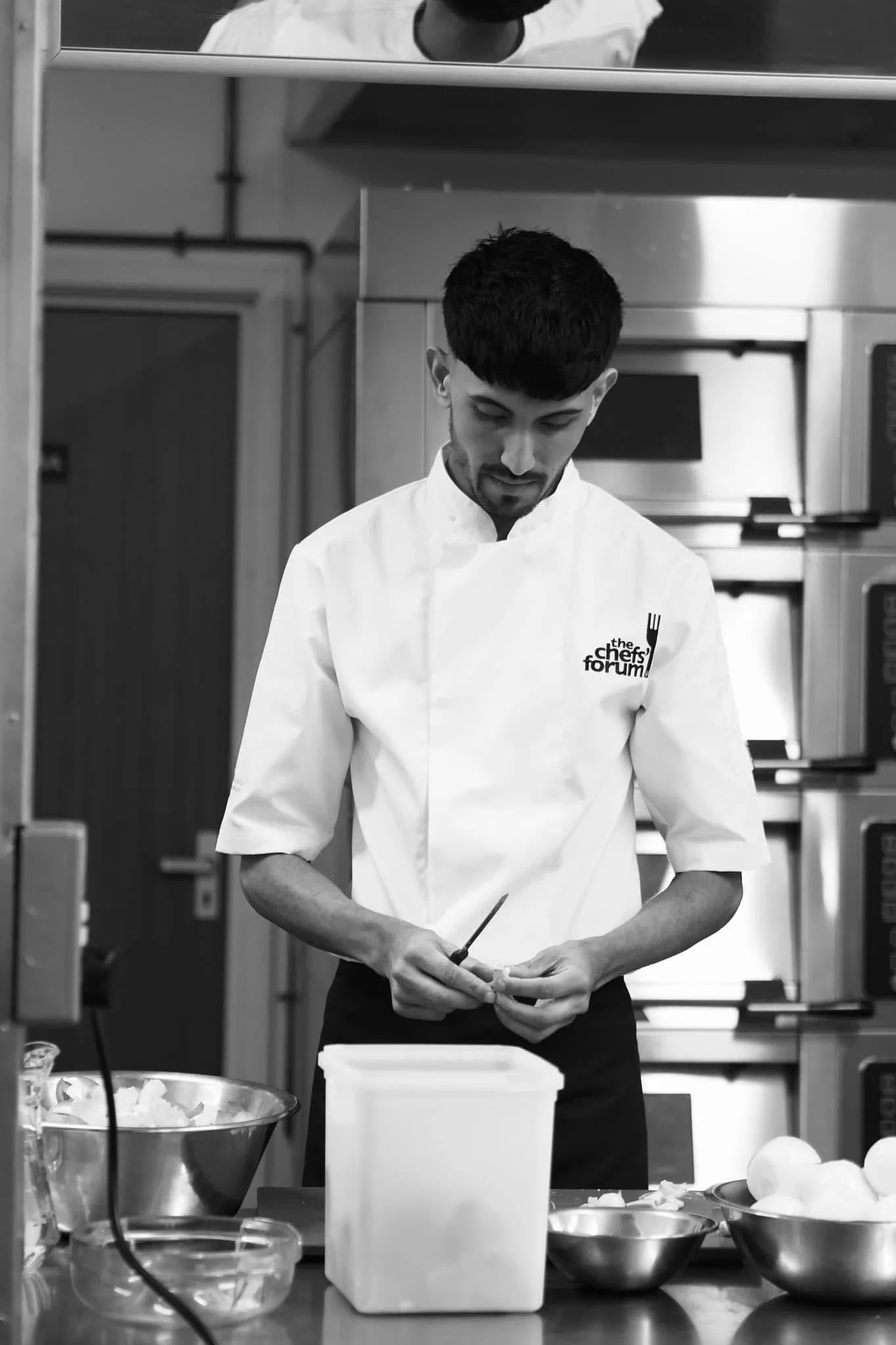 Chef Jubz at the prep bench, focused with knife in hand.